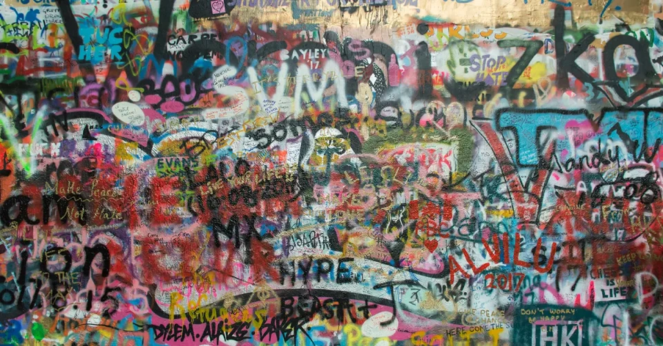 Wand mit zahlreichen Graffiti-Farbspuren
