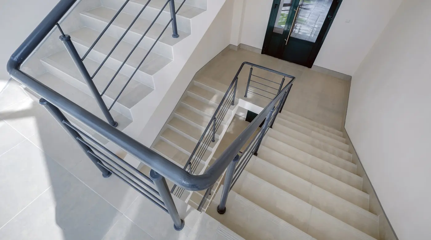 Treppenhaus mit Geländer und hellen Stufen